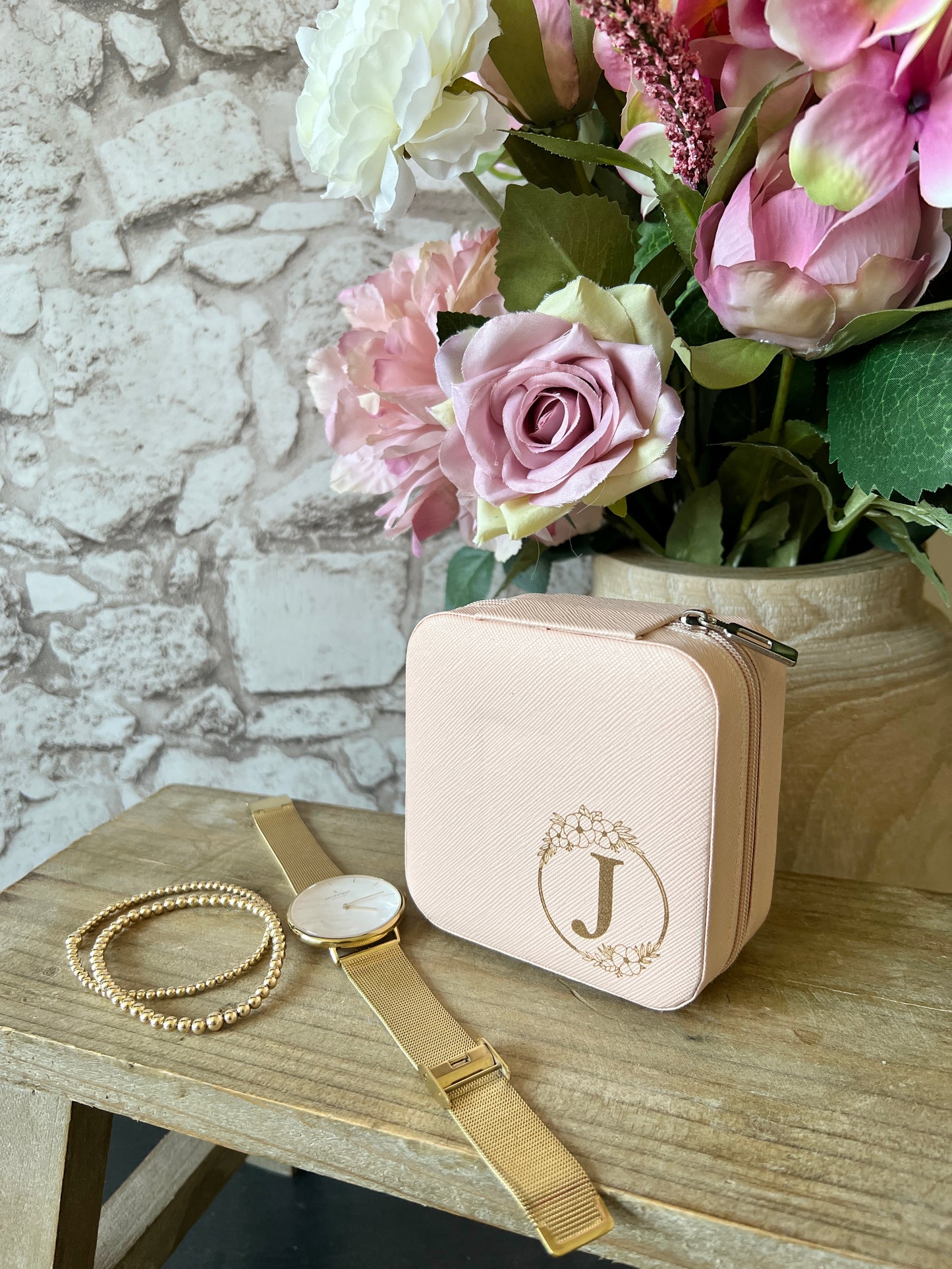 Pink jewellery box with floral circle and letter J in the middle.