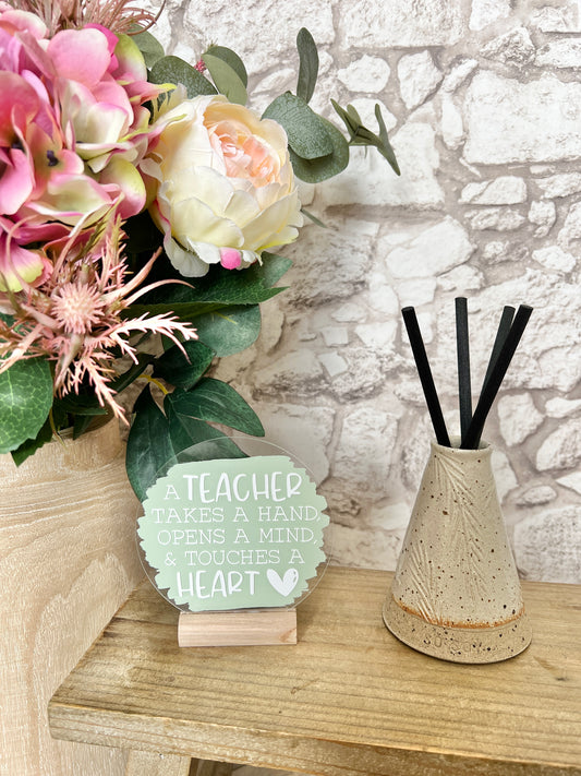 A teacher takes a hand acrylic plaque