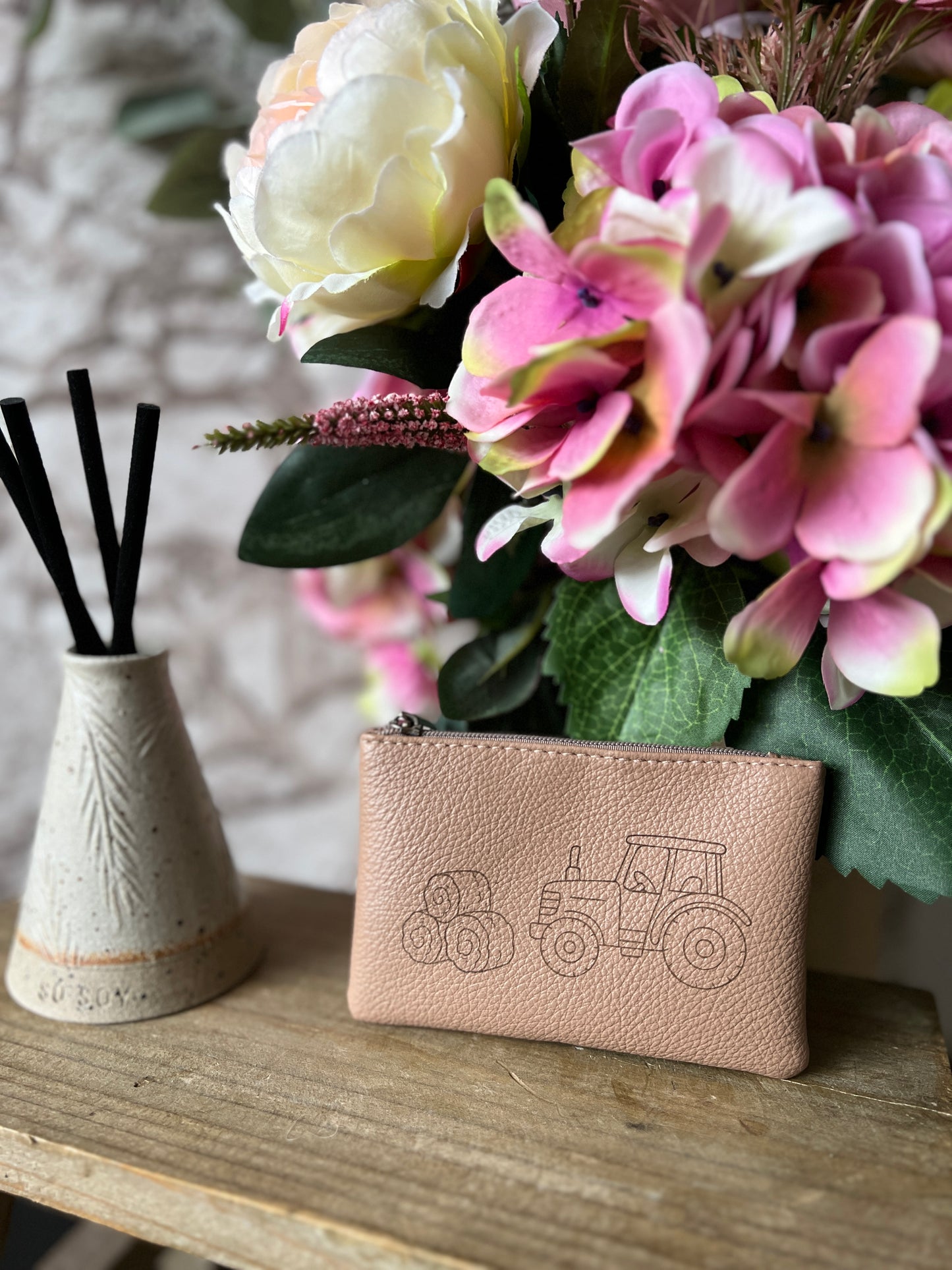 Light brown coin purse with image of a tractor with hay bales