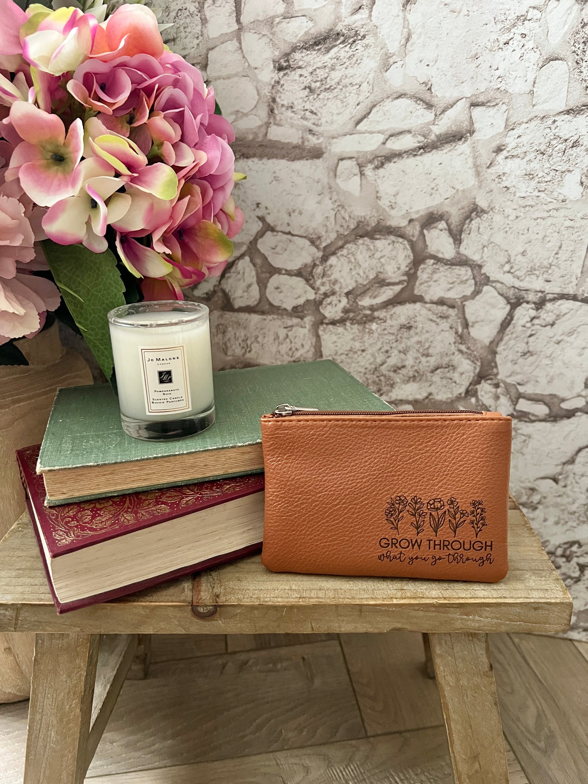 Tan coin purse with image of wildflowers and text "grow through what you go through"